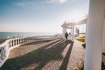 Wedding couple on a walk on the embankment near the sea