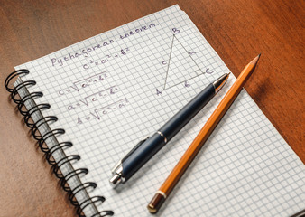 Page with formulas and the Pythagorean theorem with pen and pencil