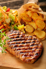 Grilled chicken breast fillet with potato chips and salad