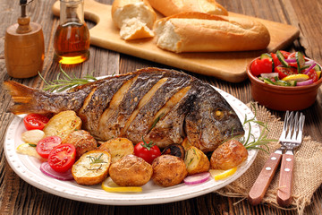 Roasted dorada fish with vegetables on wooden background - 165286836