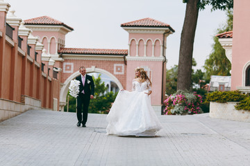 Beautiful and enamored wedding couple walking outdoors