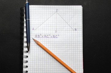 Page with formulas and the Pythagorean theorem with pen and pencil