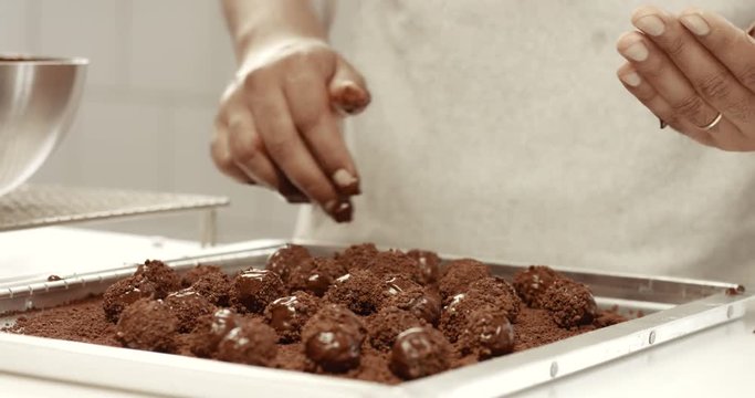 Chocolate master in his factory makes a truffles. Chocolate truffles making of process. Chocolate texture. Small business factory. Sunny chocolate factory