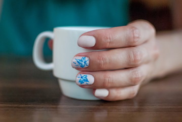 Beautiful manicure made on the nails on the fingers with colored varnish