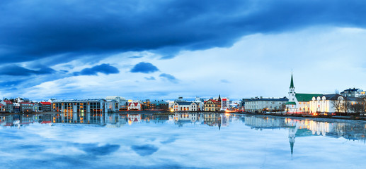 Beautiful panorama of the skyline cityscape of Reykjavik, reflected in lake Tjornin at the blue...