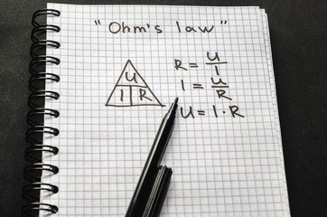 Page with formulas and Ohm's law with pen