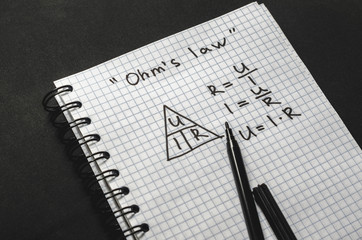 Page with formulas and Ohm's law with pen - 165290878