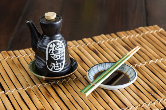 Soy sauce bottle and chopstick on the bamboo mat.
