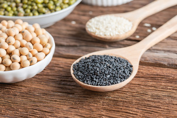 Black sesame and White sesame, nut on wood background.