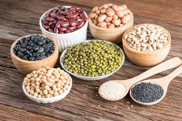 Mixed beans and sesame on wood background.