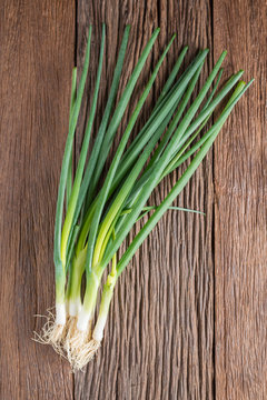 Spring onions on wood background.
