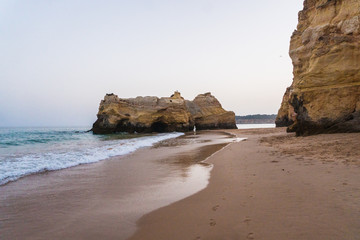 Beautiful atlantic ocean view horizon with sandy beach rocks and waves at sunset algarve. Summer time