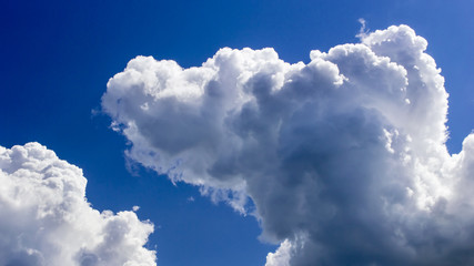 Naklejka na ściany i meble a big and fluffy cumulonimbus cloud in the blue sky