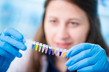 Young female technician in genetic laboratory with PCR
