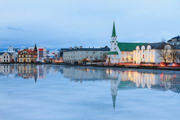 Beautiful reflection of the cityscape of Reykjavik and the Free church in lake Tjornin at the blue...