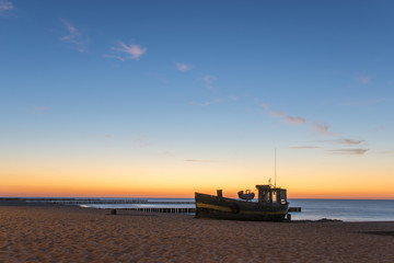 Obraz premium Fishing boat on the beach in the evening