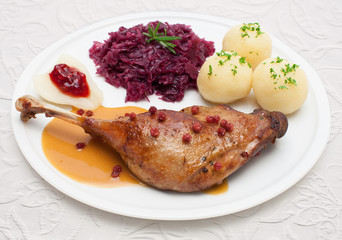 Gänsekeule mit Rotkohl, Klößen und Cranberry-Sauce - Festtagsessen auf weißer Tischdecke - 165295498