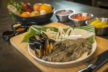 Raw seafood on plate with fruits and vegetables, healthy food, prawn, clam squid