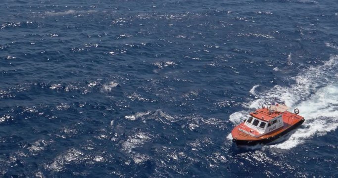 A wide shot of a small pilot ship cutting through the ocean waters. Shot at 48fps.  	