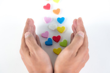 Colorful hearts sending  out from hands on white background, love concept
