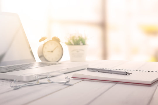 Businessman making notes at the office meeting with computer laptop and glasses.