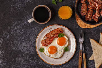 Breakfast with bacon , fried egg, coffee and orange juice.