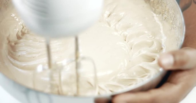 mixed race baker makes a cake. Closeup and slow motion of mixing a dough
