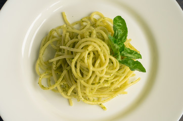 Italian pasta spaghetti with homemade pesto sauce and basil leaf