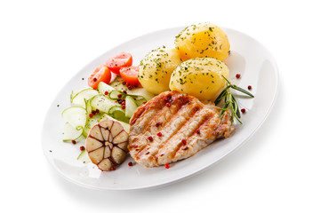 Grilled steak, boiled potatoes and vegetable salad on white background