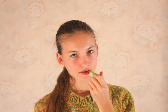 blonde Girl in green dress applying lipstick
