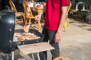 Friends making barbecue and having lunch in the nature.
