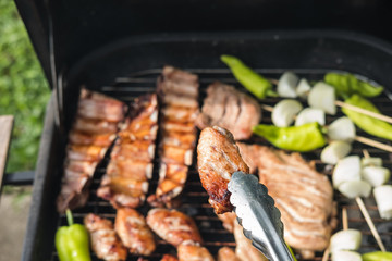 Friends making barbecue and having lunch in the nature.