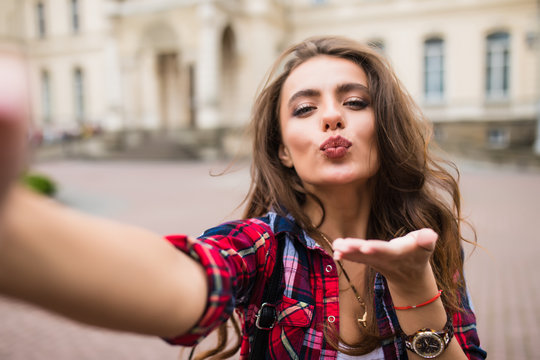 Young girl take selfie from hands with phone on summer city street urban life concept