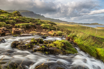 Bride's veil waterfall with Old man of Storr in the background. Isle of Skye, Scotland.