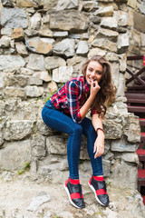 Pretty young slim woman posing against stone wall