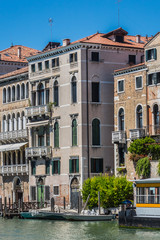 View colorful facades of the old medieval houses along the waterfront of the Grand Canal (Canal Grande). Venice, Italy.