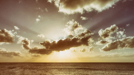 Obraz na płótnie Canvas Sunset behind the clouds towards the horizon of the Atlantic Ocean