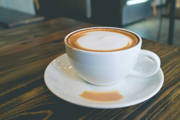 hot coffee mocha with foam milk in vintage cafe(vintage effect)