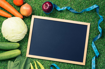 Calorie Restriction or Exercise and empty blackboard on the grass background.