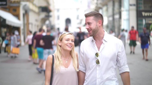 4K travel video young sightseeing couple walking in pedestrian zone in Vienna with many other blurred tourists
