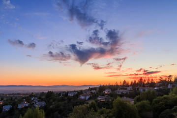 Vibrant sunset over a broad valley and homes