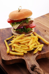 fresh tasty burger and french fries on wooden table