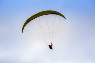 Colorful hang glider/paraglider against the blue sky