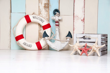 Composition on a marine theme with an anchor and life buoy, seashells and starfish on a wooden...