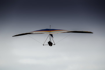 Colorful hang glider/paraglider against the blue sky