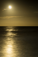 full moon rises over the Atlantic Ocean in South Carolina with a beautiful tranquil ocean