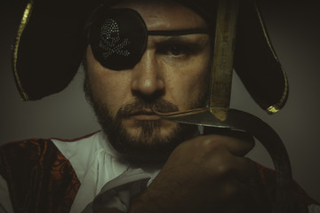Danger, Man with beard dressed like a pirate, with eye patch and steel sword