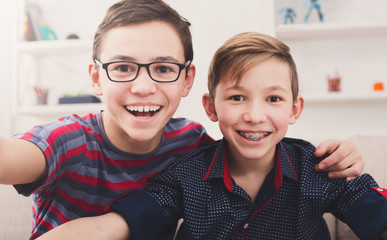 Two stylish smiling teens taking selfie