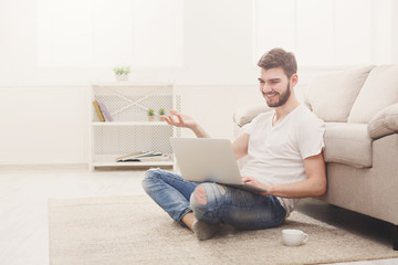 Smiling man with laptop indoors