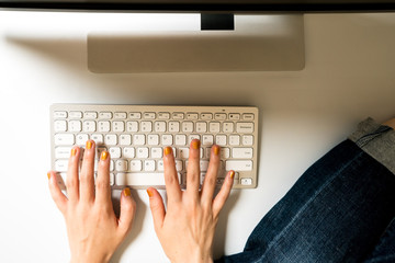 デスクに足を乗せて作業する女性